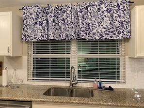 Kitchen winder overlooks backyard patio. Blinds can be closed for privacy.