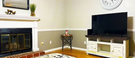 Living room with fireplace and smart TV that comes with a host of free channels.