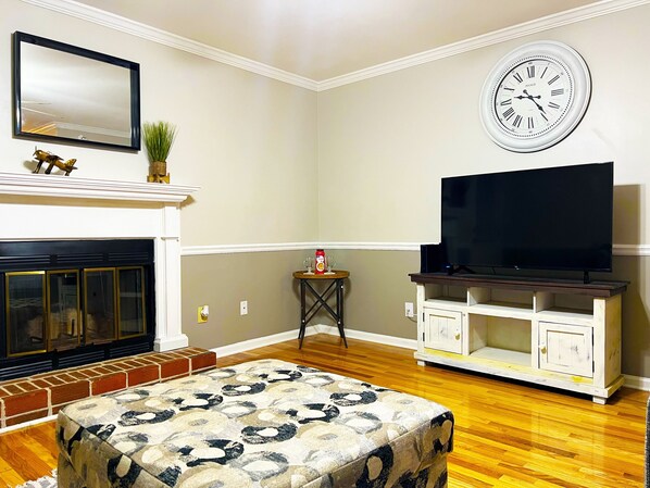 Living room with fireplace and smart TV that comes with a host of free channels.