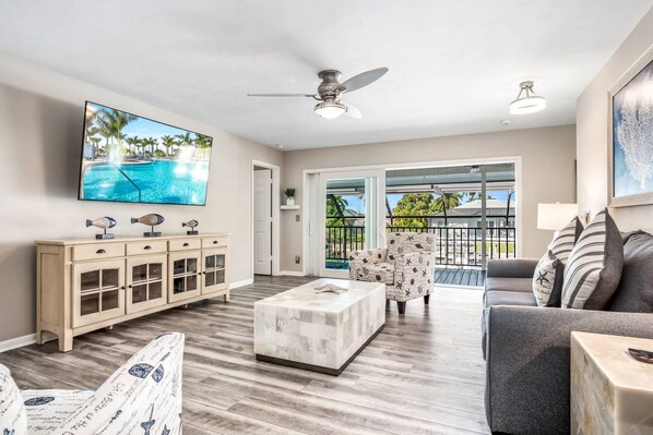 The open and bright living opens through the sliders onto the second-level balcony overlooking the pool and canal.