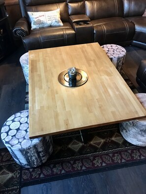 Amazing family room with sectional, coffee table with stools, fireplace, and TV