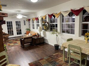 Sun room with sitting room with 43" smart TV and dining table