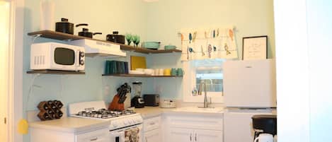 Kitchen with all essentials: pots. pans, seasoning, stove, fridge, coffee, etc
