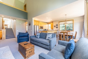 Living area with new furnishings, Smart TV, vaulted ceilings, and a gas fireplace with beautiful stone surround.