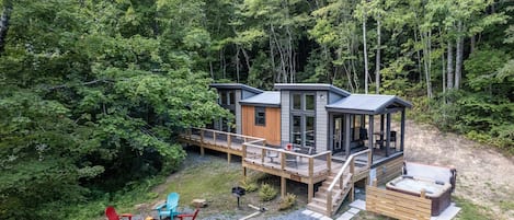 Exterior View - Exterior view of home showing driveway, firepit with seating, and hot tub area.