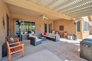 Backyard covered patio area with seating and outdoor heaters
