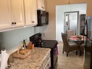 Nice view of the galley-style kitchen with photo of dining room in background.