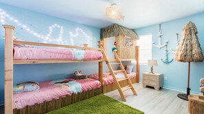 Tropical-themed kids' room with bunk beds, tiki hut, and fun decor!