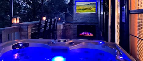 Pigeon Forge Cabin - Majestic Poolside Lookout - Covered back deck with hot tub and outdoor kitchen at night