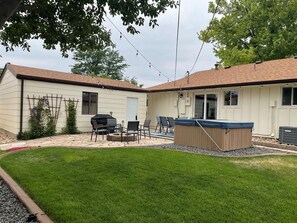 Spacious backyard with hot tub, fire pit, and patio entertainment.