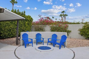 Seating around the firepit with view of the pool and mountains