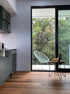 Light filled kitchen/dining area with balcony view over bushland