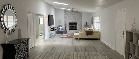 entry area with family room at end where fireplace is & 2 bdrms/1ba off to left