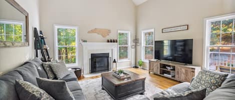 ~Imagine relaxing in this inviting living room, basking in natural light from large windows with stunning views of nature. Gather with friends and family to watch your favorite show, sip your favorite beverage, and warm up by the cozy fireplace.
