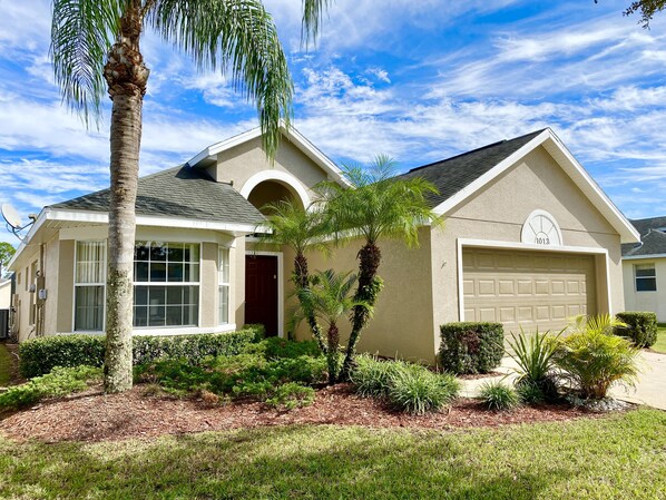 Beautiful front view of your vacation home, surrounded by lush landscaping.