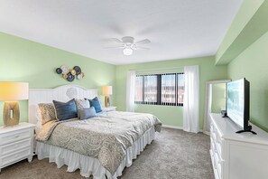 Master bedroom with king-sized bed, plush pillows, and a TV for lazy mornings and cozy nights.