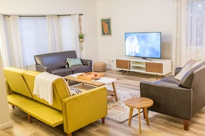 Bright Living Room with Smart TV: Unwind in a spacious living room with a modern design, comfortable seating, and a smart TV for entertainment.