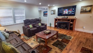 The warm and cozy living area offers leather recliners and sofa with recliners on each end. There are gas logs and a flatscreen TV as well.