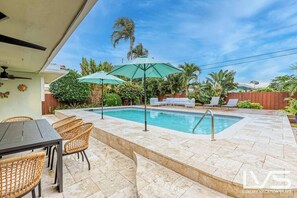 Tropical Fenced in Private Backyard with Heated Pool, outdoor dining table, lounge chairs, BBQ and plenty of seating/hammocks. 