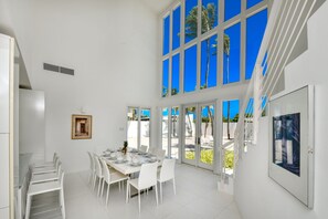 Ritardando Dining Area of the Villa in Noord Aruba - High ceilings creating sense of spaciousness - 8 Persons Dining - Floor-to-ceiling windows flood the space with natural light, offering stunning views