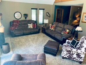 Great Room with reclining sofas, reclining chair, chair & ottoman & ceiling fan.