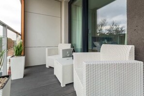 Spacious balcony with outdoor furniture. 
