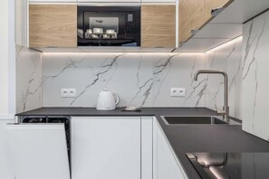 Kitchenette with plenty of kitchen utensils and dishes. 