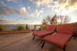 Chaises longues sur une terrasse spacieuse avec vue sur la mer Adriatique.