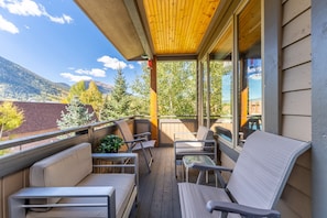 Private balcony with outdoor furnishings and gas grill off the main living area.