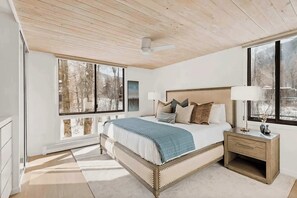 Primary bedroom with ceiling-to-floor windows w/ view of Roaring Fork river below.