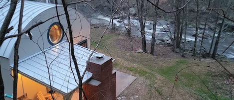 Outdoor kitchen with fireplace and 50" TV overlooking Elk River