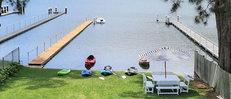 Private jetty, kayaks and seating under the shade of a tree