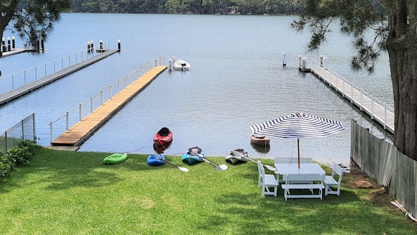 Private jetty, kayaks and seating under the shade of a tree