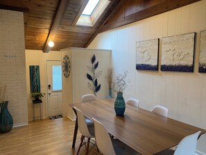 Dining area with high ceiling and skylight