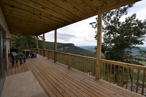 Massive lower deck facing toward the bluff.  Includes a propane BBQ grill.