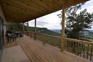 Massive lower deck facing toward the bluff. Includes a propane BBQ grill.