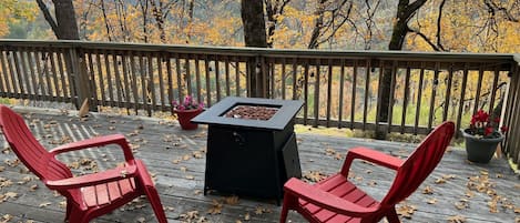 Gas fire pit on the back deck, surrounded by beautiful oak trees.