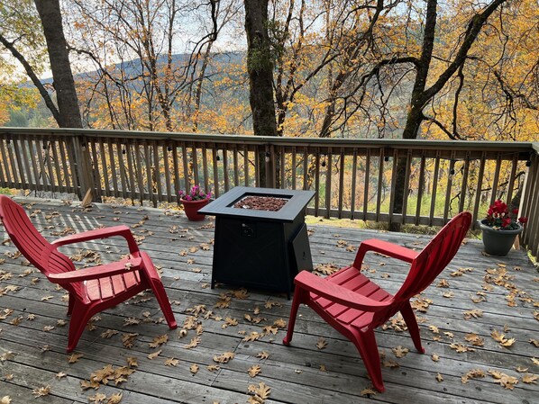 Gas fire pit on the back deck, surrounded by beautiful oak trees.