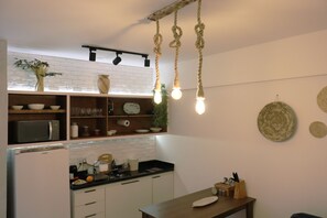 Cozinha equipada com cooktop, microondas, liquidificador, cafeteira, sanduicheir