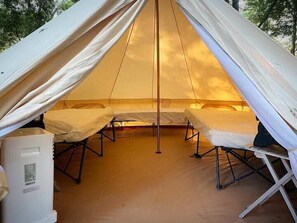 2 Queen sized beds, 1 twin bed, side table, fans, electricity, and AC/Heat. Guest provides bedding.