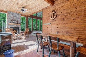 Three seasons room with table, wood burning fireplace and hot tub 