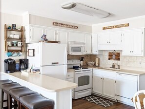 Fully stocked kitchen includes seating for 2 at the table and 4 at the counter.