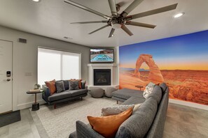 Hip Moab-themed family room with fireplace, TV and large mural