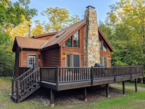 Log cabin, with large deck including grill, and patio set.