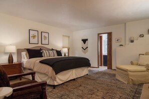 The master bedroom is very spacious with a king bed, seating and smart TV. 