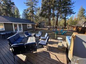 Backyard Deck with Fire pit table and seating, and large hot tub. 