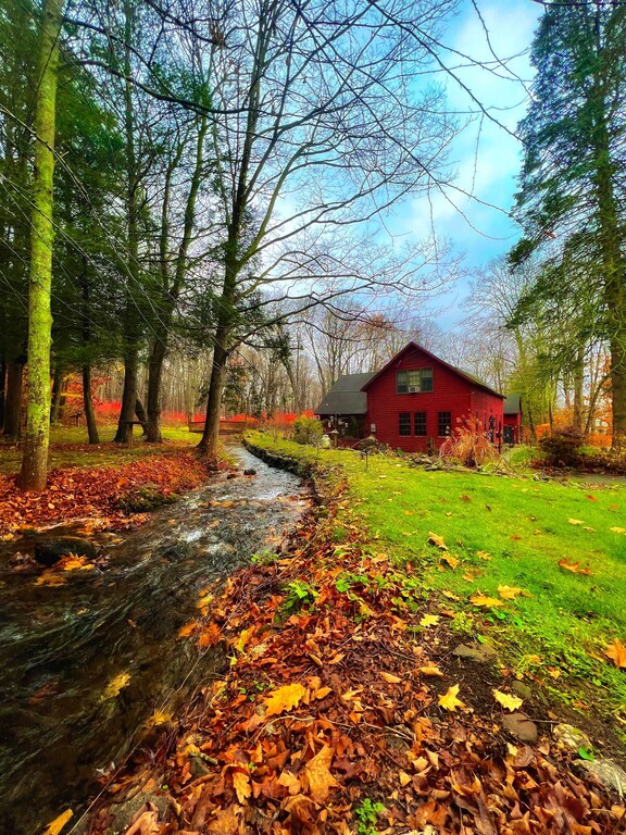 A historic Connecticut cabin is tucked away beside a stream