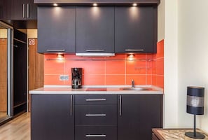 Kitchenette with plenty of kitchen utensils and dishes.