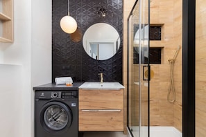Bathroom with washing machine and towels. 