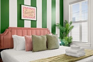 Welcome to Beverly Hills! This room was specifically inspired by the Beverly Hills Hotel. The striped walls and pink bed frame is the perfect background for TIKTOKs, Instagram Reels or Photos.